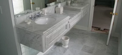 Bright bathroom remodel in Sandy Springs, GA with two rectangular sinks, chrome faucets, marble countertop, and a large mirror.