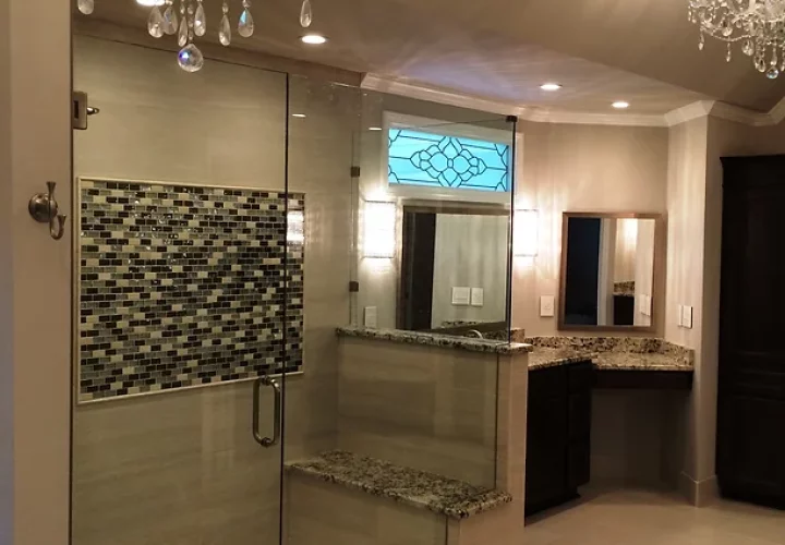 A luxurious bathroom with a modern walk-in shower and a sparkling chandelier.