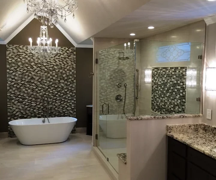 A luxurious bathroom featuring a soaking tub, a glass-enclosed shower, and an elegant chandelier.
